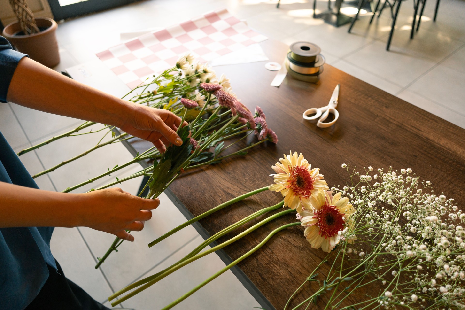 Woman's hand preparing flower bouquet in flower shop